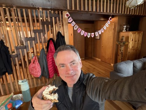 Daddy, bagel in hand, under the banner